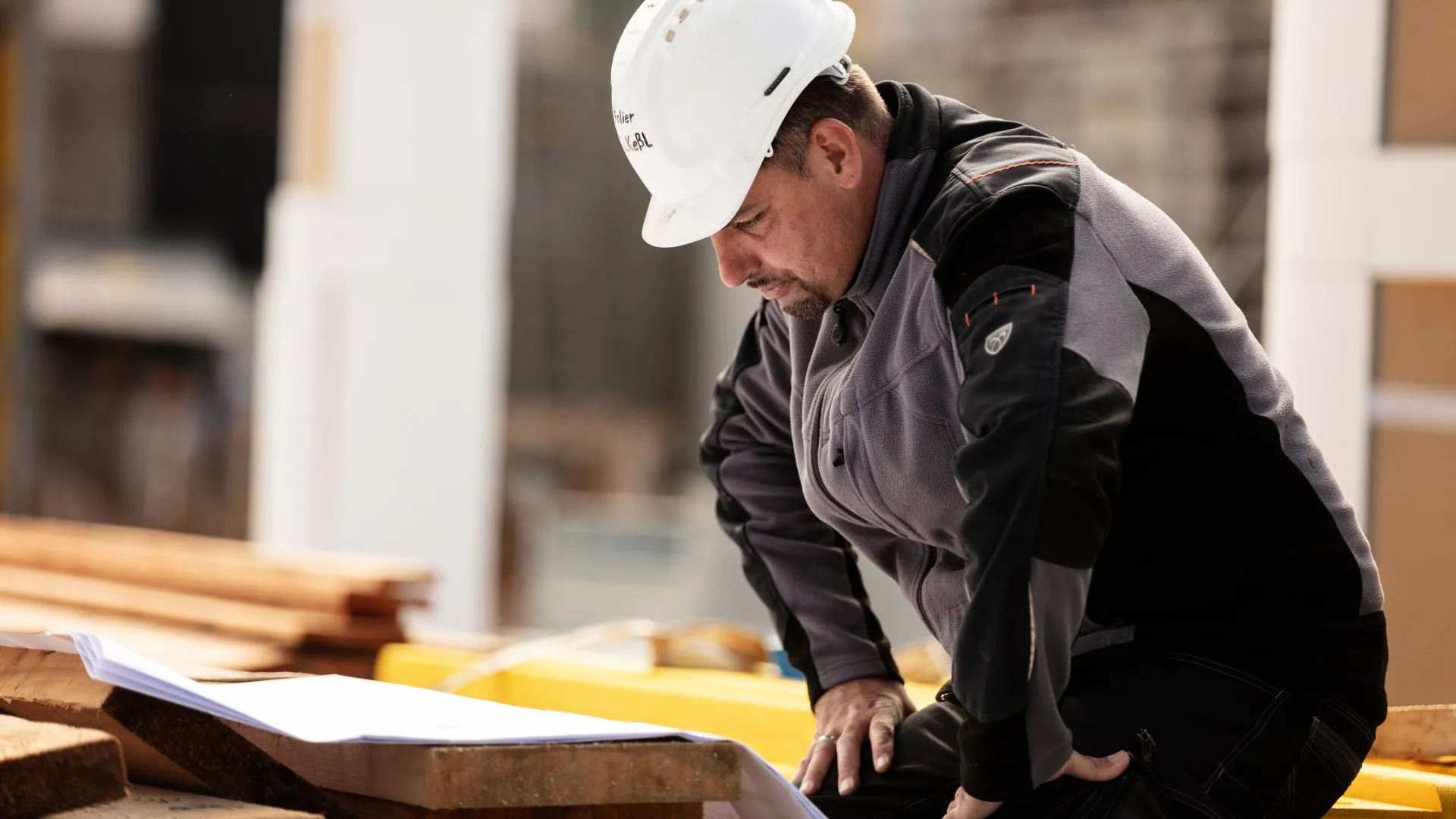 Bauleiter prüft Pläne auf der Baustelle