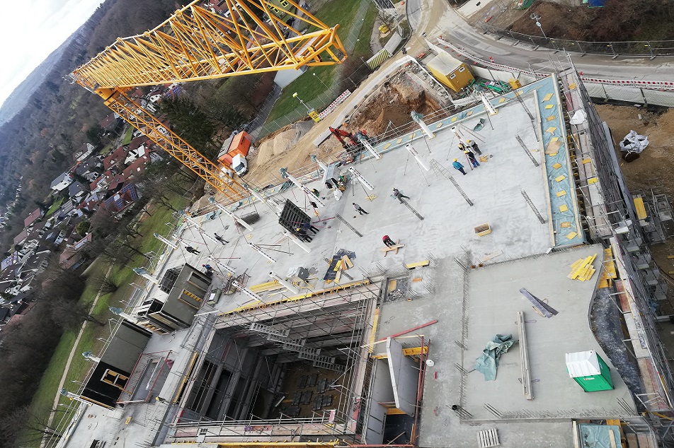 Baustelle mit Kran und Baugrube von oben